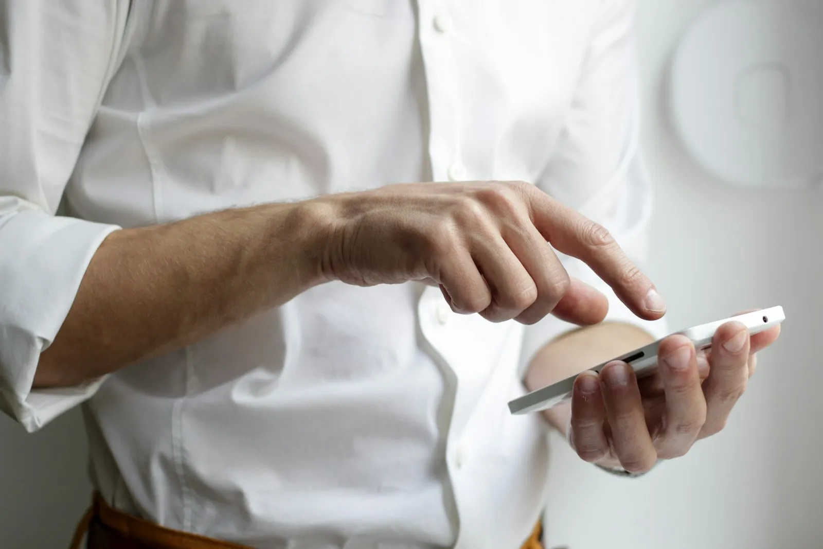 Eine Hand hält ein Smartphone und tippt auf den Bildschirm